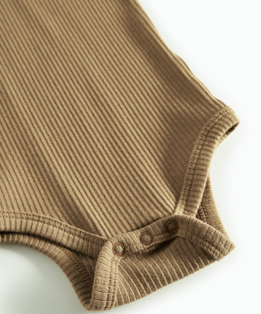 Brun ribstrikket babybody med lange ærmer og knapper mellem benene