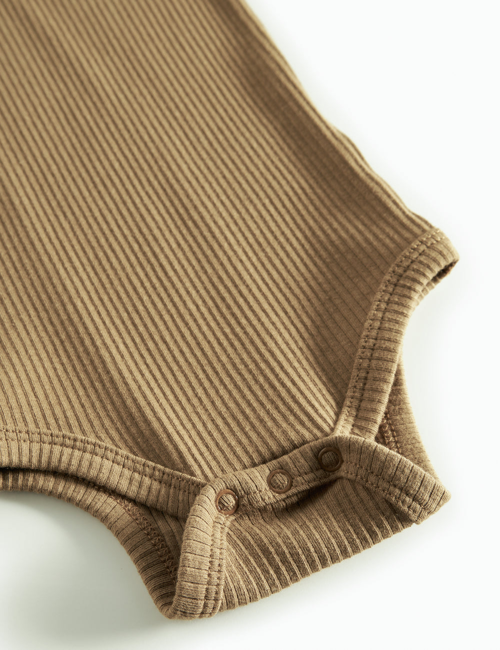 Brun ribstrikket babybody med lange ærmer og knapper mellem benene