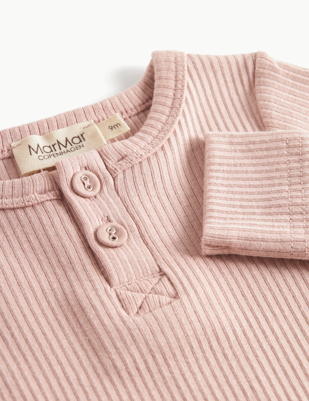 Ribbstrikket lyserød holdragt til baby i blødt materiale med lange ærmer, lange ben og knapper.