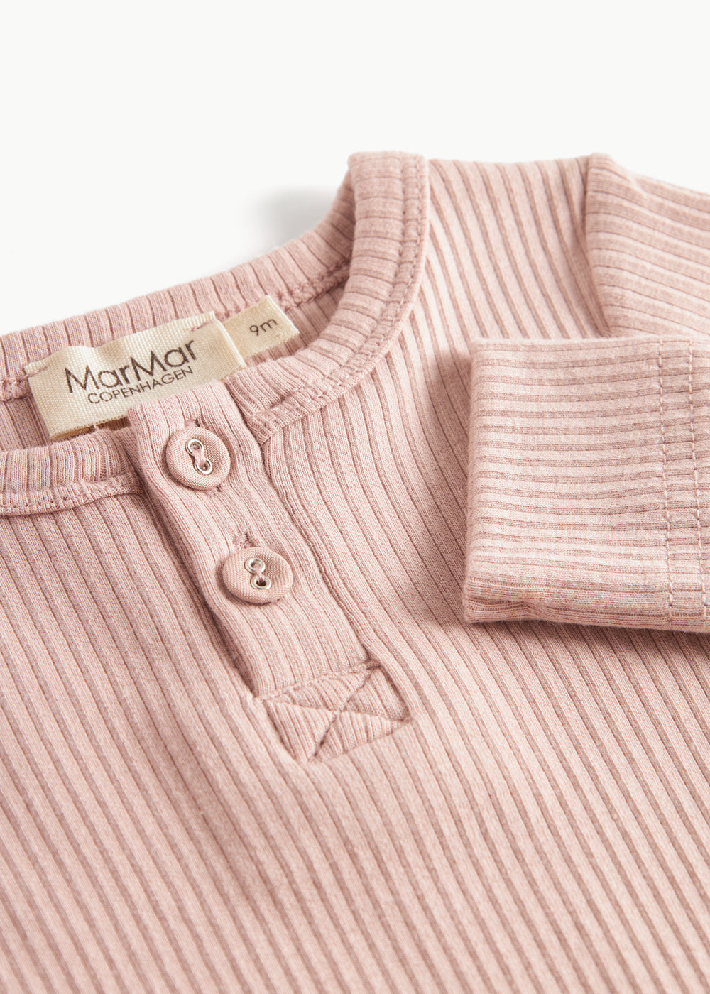 Ribbstrikket lyserød heldragt til baby i blødt materiale med lange ærmer, lange ben og knapper