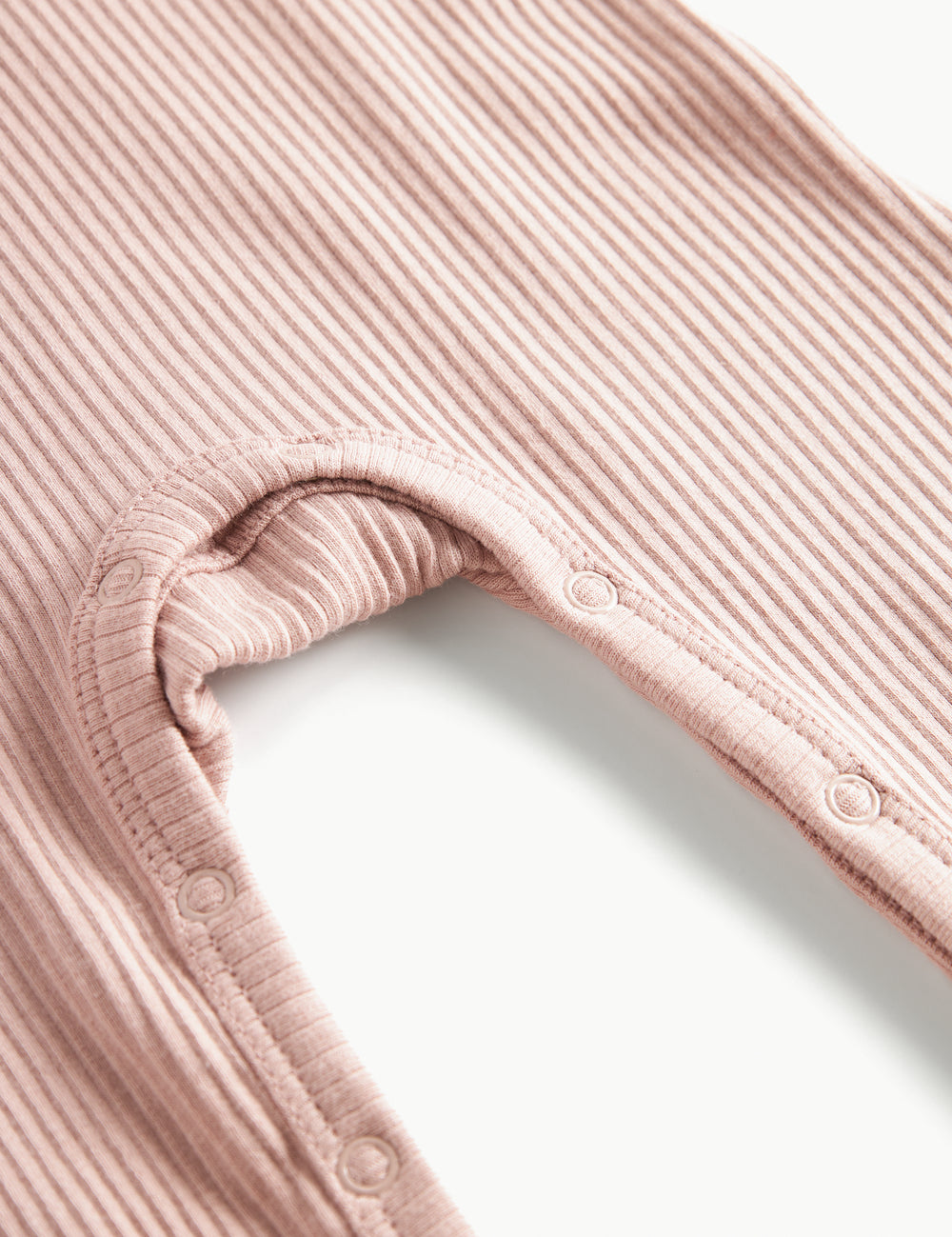 Ribbstrikket lyserød holdragt til baby i blødt materiale med lange ærmer, lange ben og knapper.