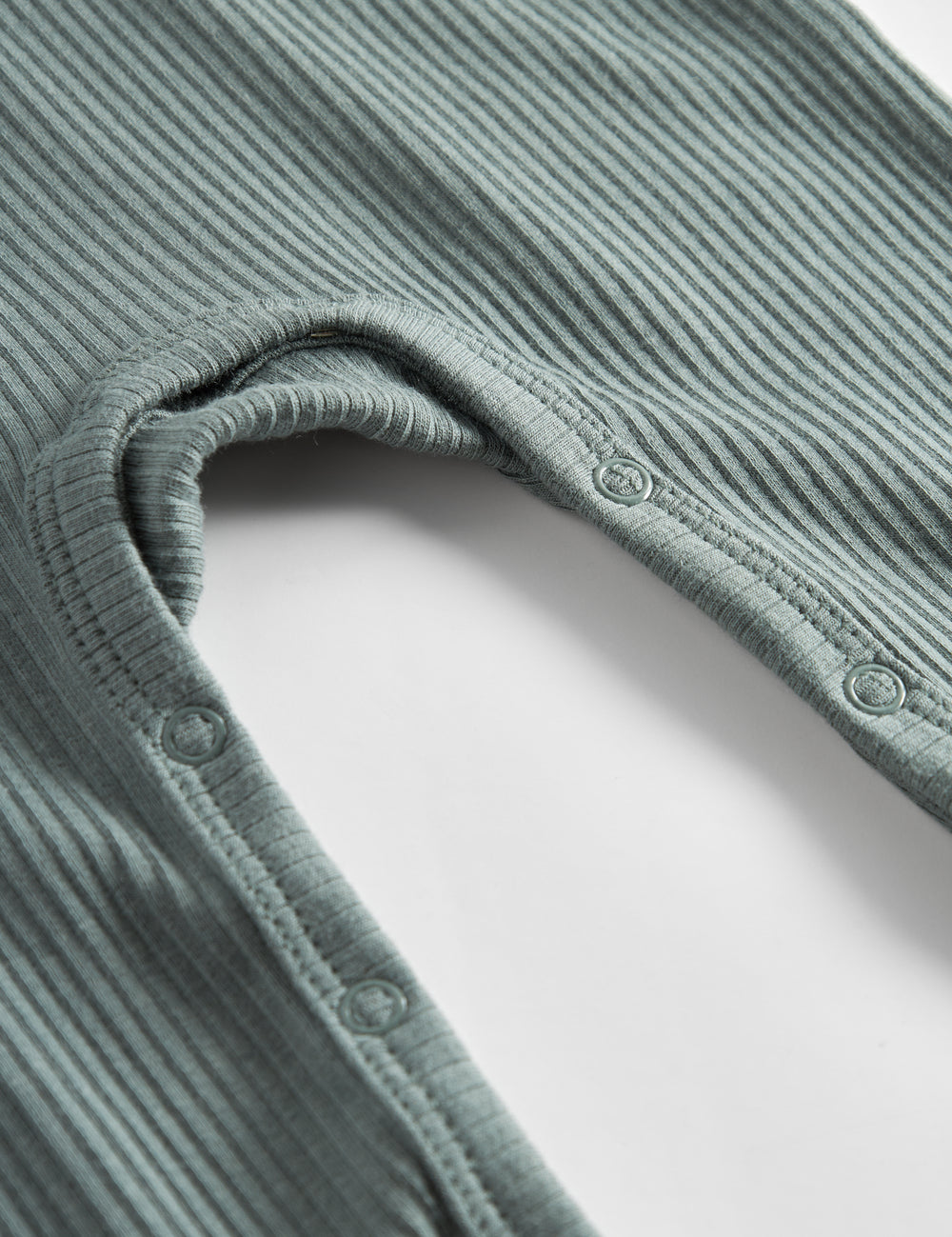 Grøn ribstrikket holdt med lange ærmer og ben og knapper til baby