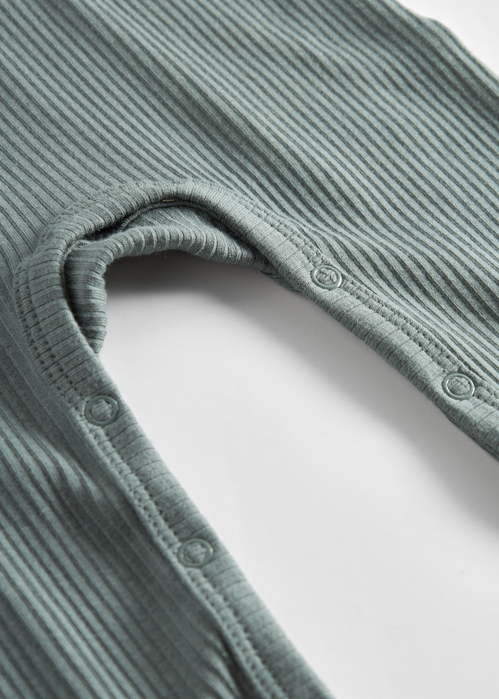 Grøn ribstrikket heldragt med lange ærmer og ben og knapper til baby