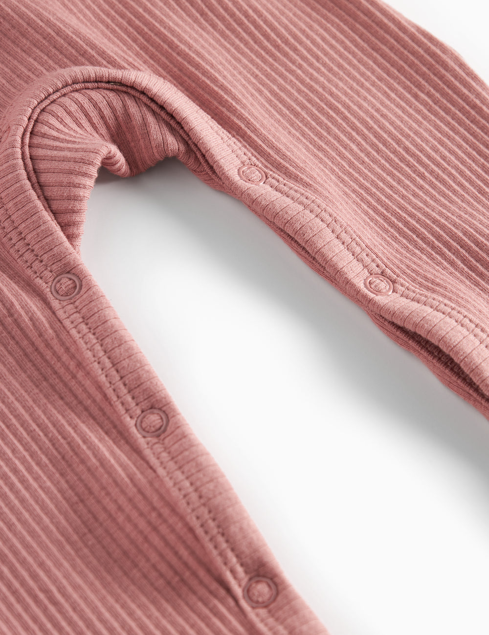 Lyserød ribstrikket holdt med lange ærmer og ben og knapper til baby