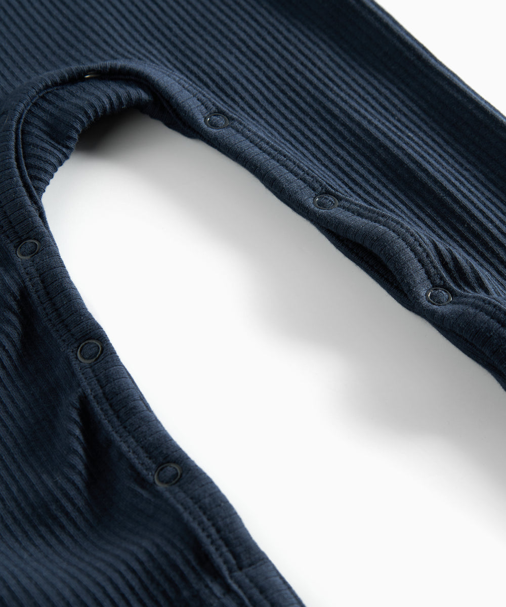 Ribbstrikket blå heldragt til baby i blødt materiale med lange ærmer, lange ben og knapper