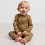 Baby iført ribbstrikket brun heldragt i blødt materiale med lange ærmer og lange ben og lynlås