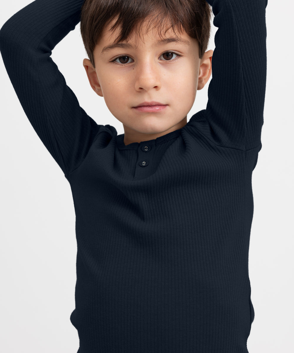 Dreng iført blå ribstrikket langærmet t-shirt med knapper