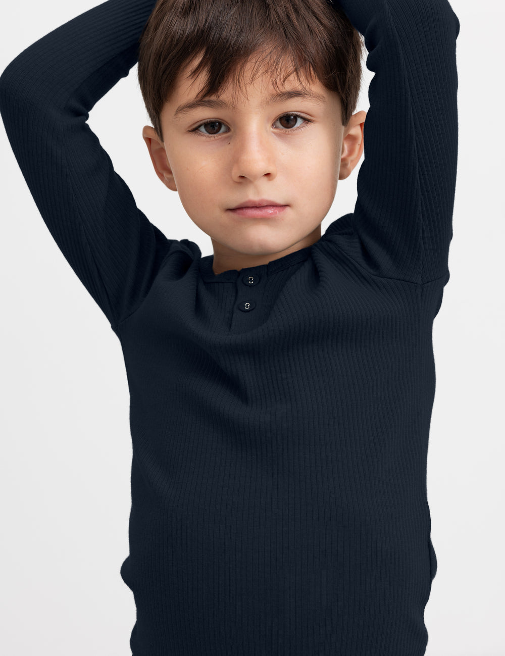 Dreng iført blå ribstrikket langærmet t-shirt med knapper