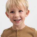 Glad dreng iført brun ribstrikket langærmet t-shirt