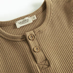 Detalje af brun ribstrikket langærmet t-shirt med knapper