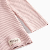 Detalje af ribstrikket nederste kant på rosa børnetøj