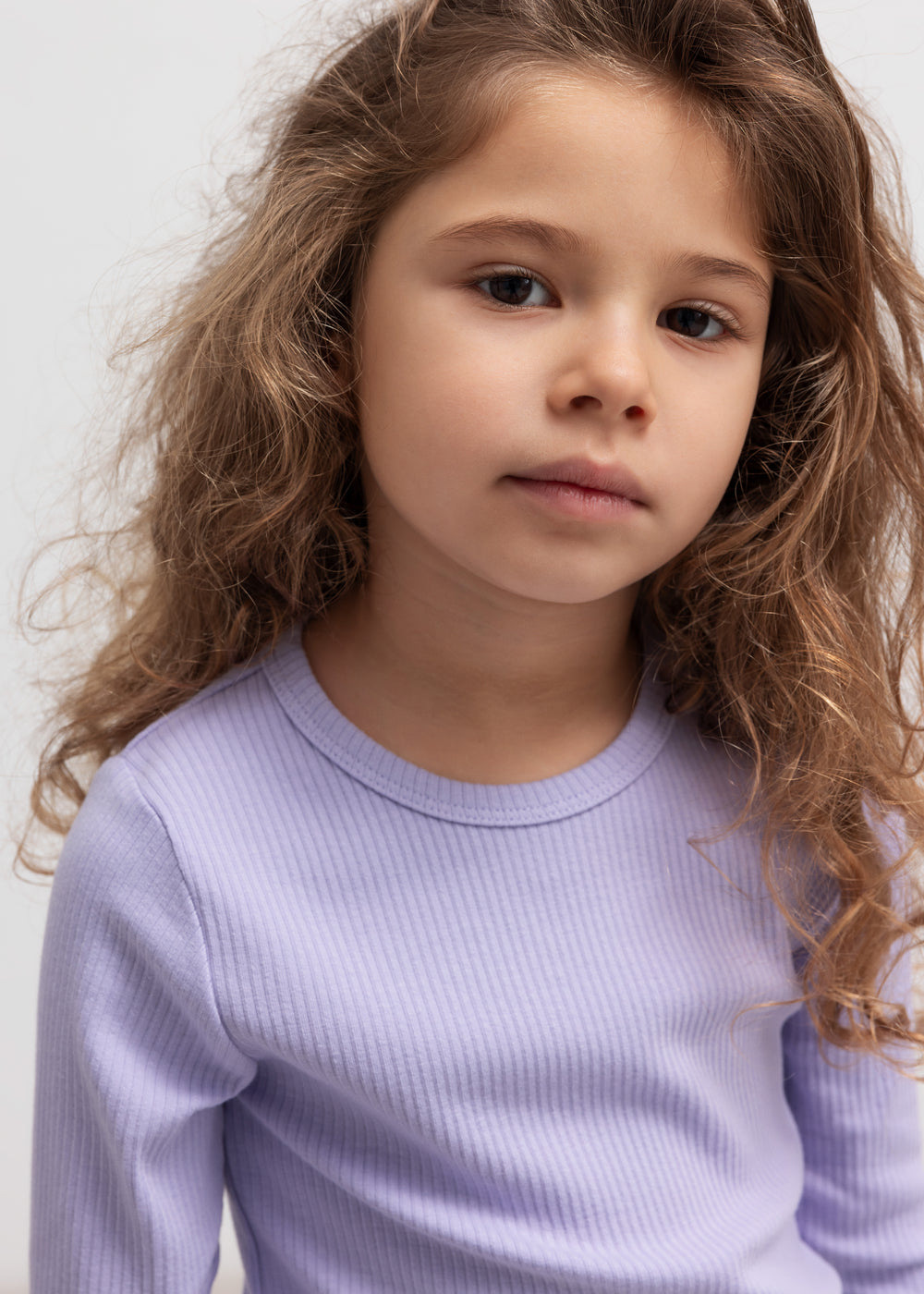 Lille pige iført lilla ribstrikket t-shirt til børn