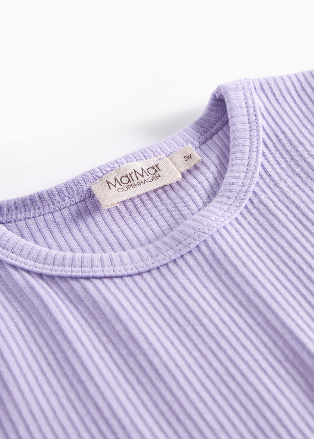 Detalje af ribstrikket lilla børnetøj med mærke