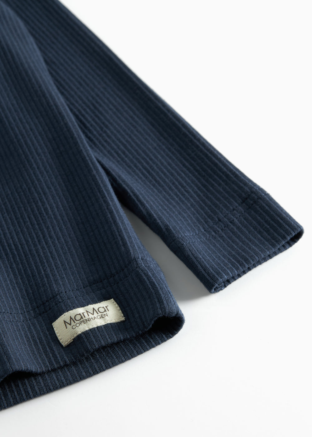 Nærbillede af ribstrikket stof og mærkat på navyblå børne t-shirt