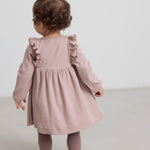 Børn iført lyserød ribstrikket kjole med flæsedetaljer og lange ærmer