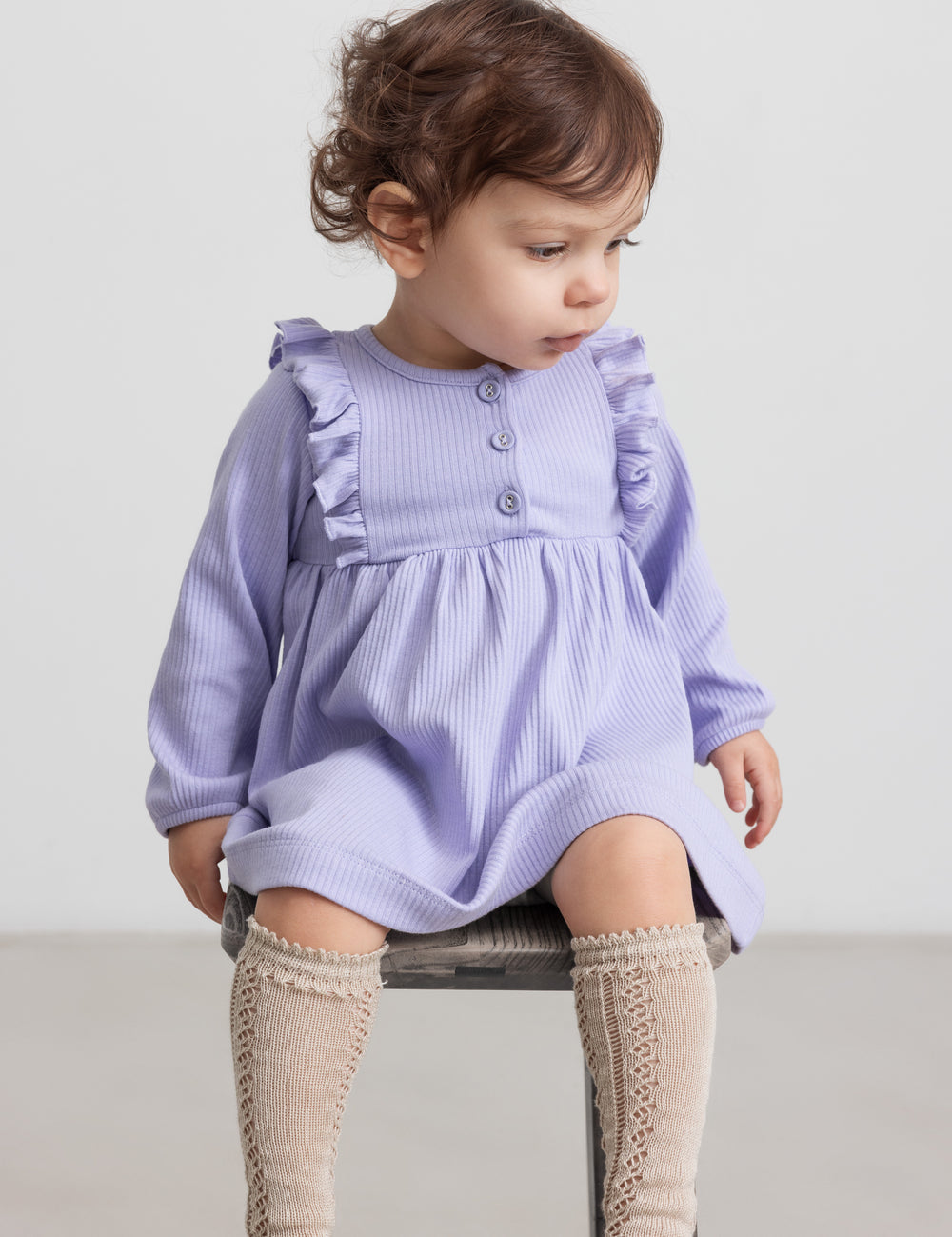 Børn iført lilla ribstrikket kjole med flæsedetaljer og lange ærmer