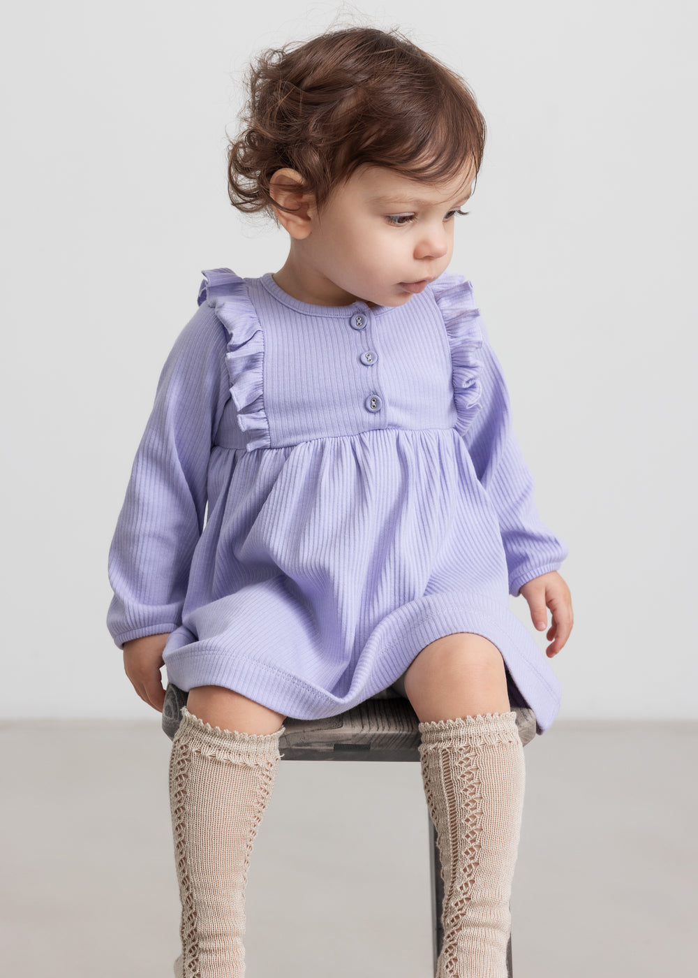 Børn iført lilla ribstrikket kjole med flæsedetaljer og lange ærmer