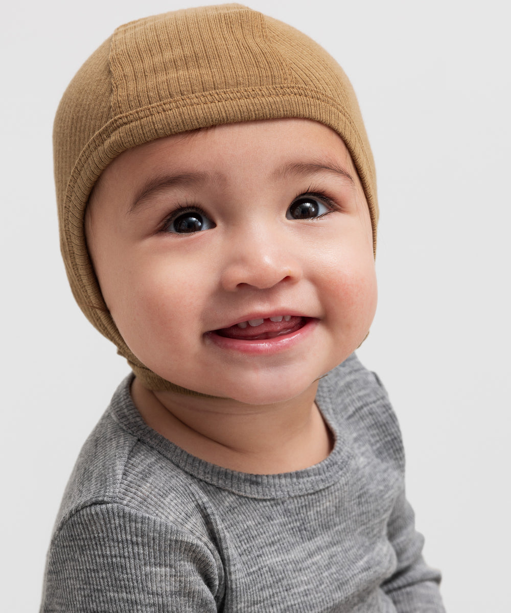 Glad baby med ribstrikket brun hue