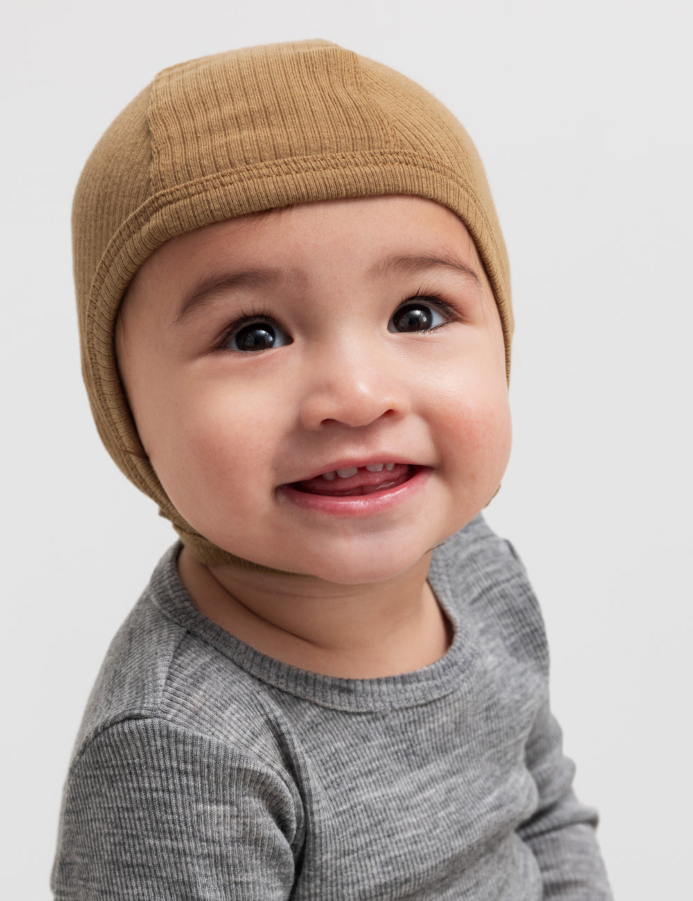 Glad baby med ribstrikket brun hue