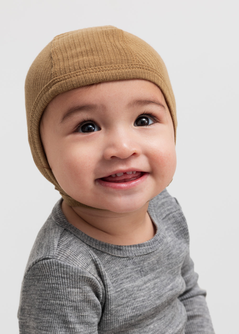 Glad baby med ribstrikket brun hue