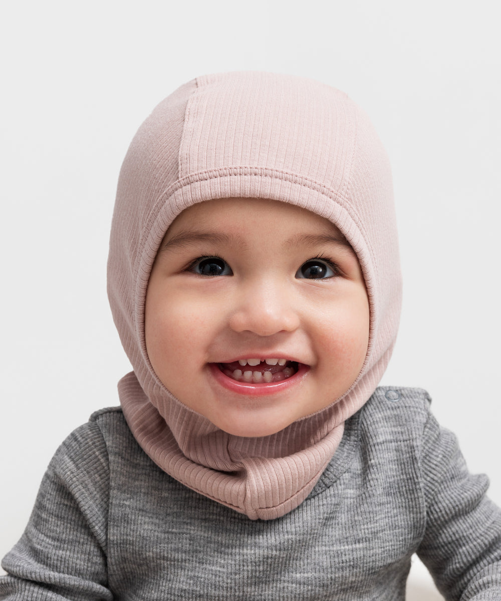 Glad baby med ribstrikket lyserød elefanthue