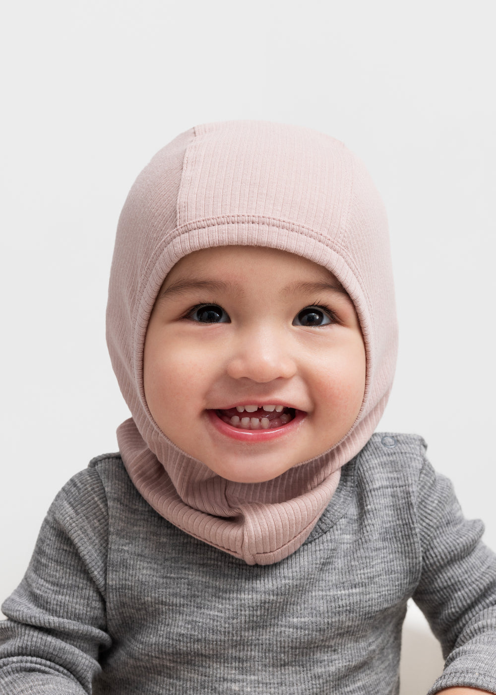 Glad baby med ribstrikket lyserød elefanthue