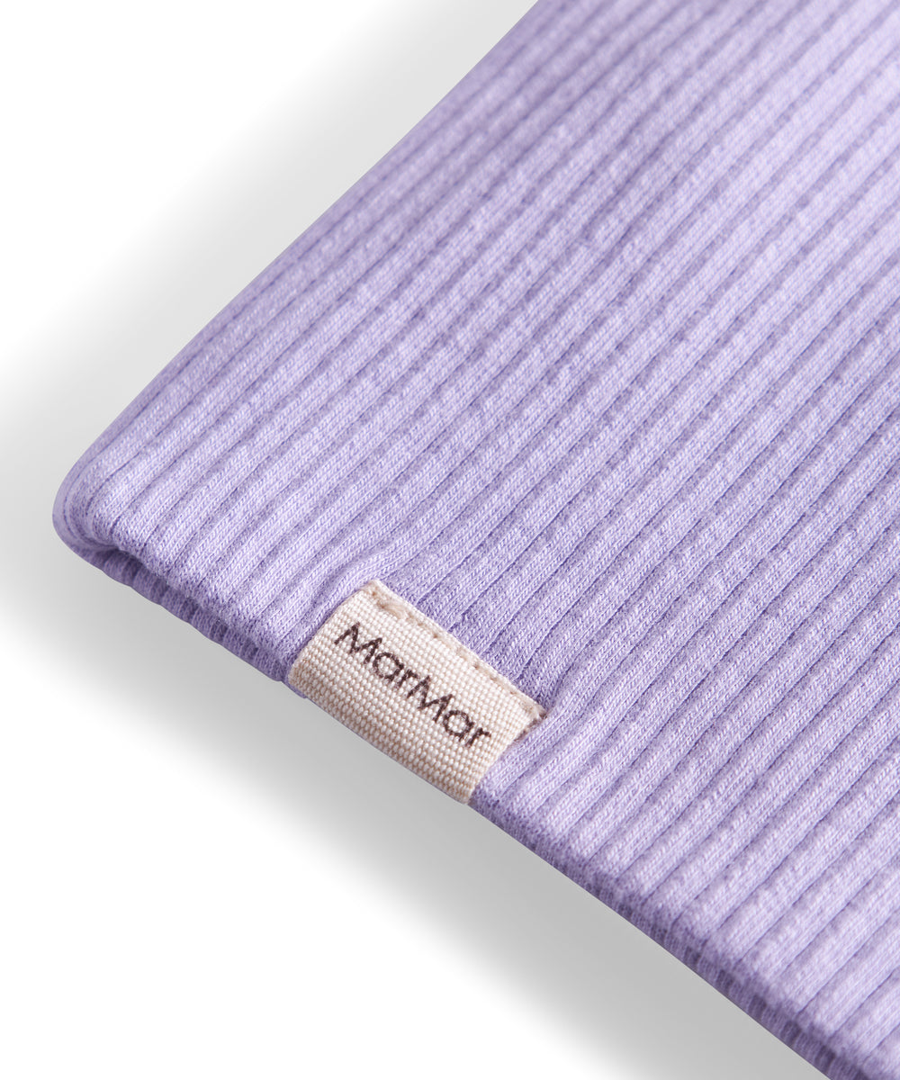 Detalje af ribstrikket lyse lilla stof og mærke på børnehue