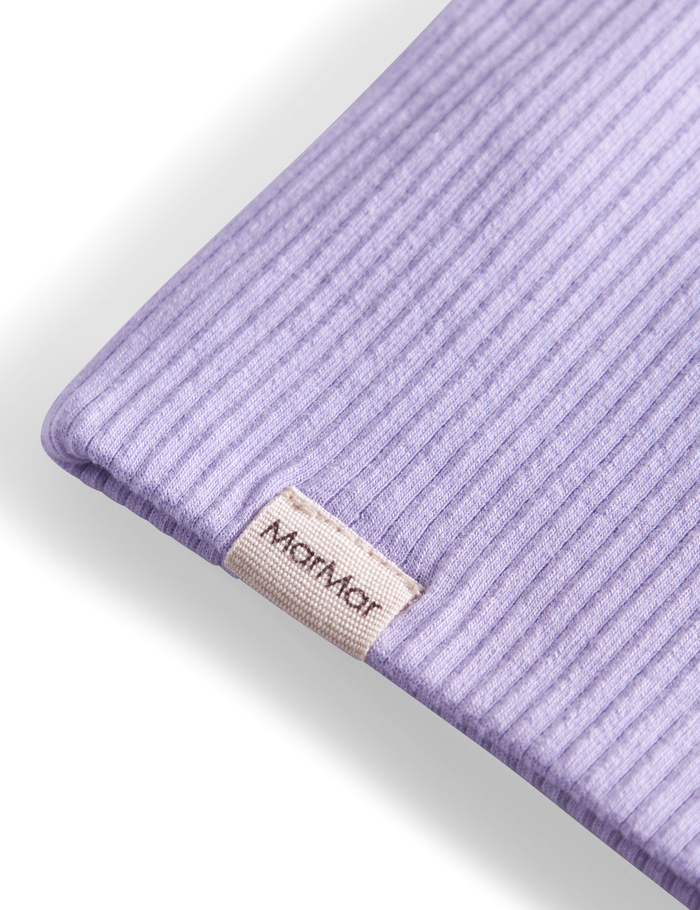 Detaljer af ribstrikket lyse lilla stof og mærke på børnehue