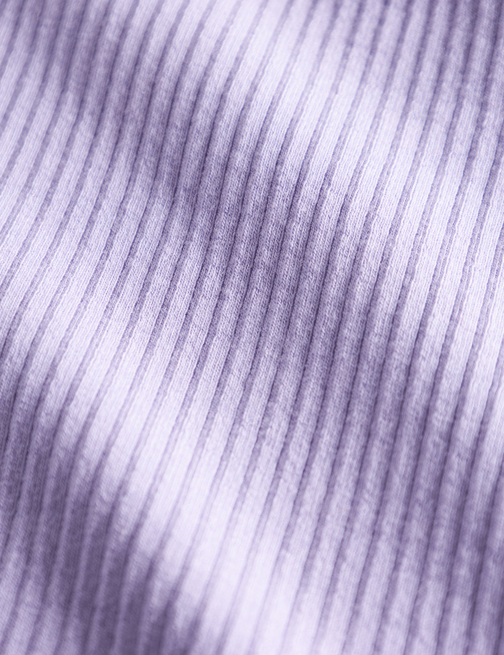 Detalje af lyse lilla ribstrikket stof på børnehue