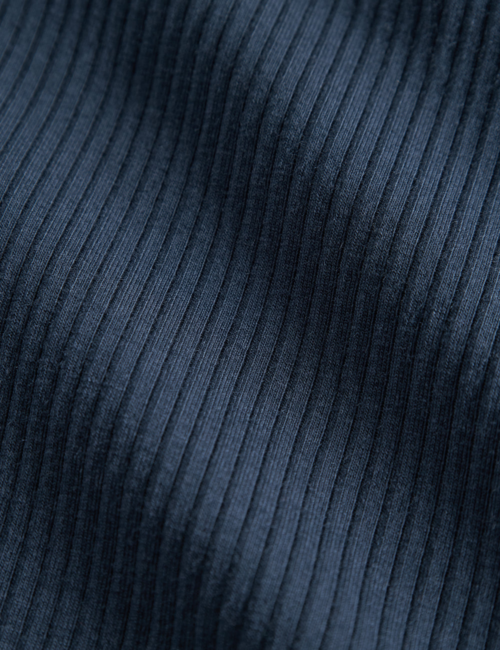 Detalje af navy blå ribstrikket stof på børnehue