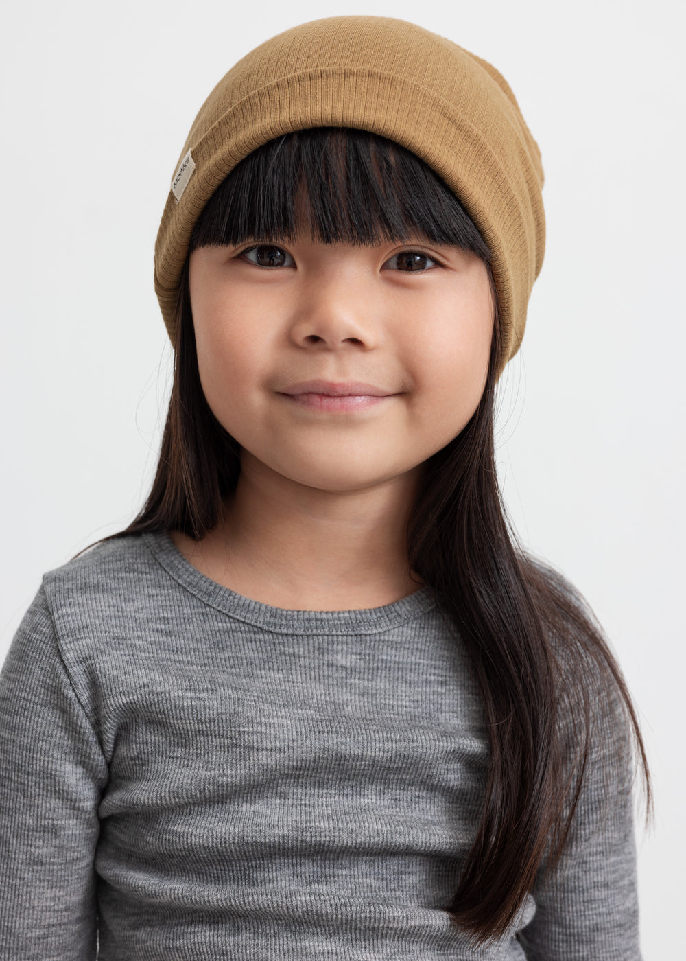 Børn med brun ribstrikket hue og grå trøje
