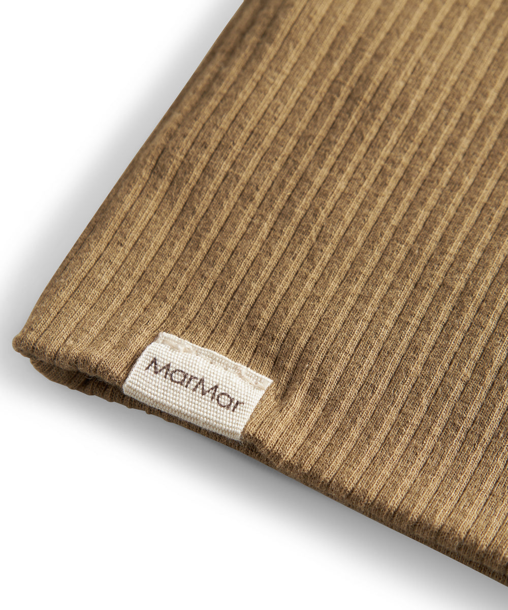 Detalje af ribstrikket stof og mærke på brun beanie til børn