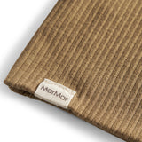 Detalje af ribstrikket stof og mærke på brun beanie til børn