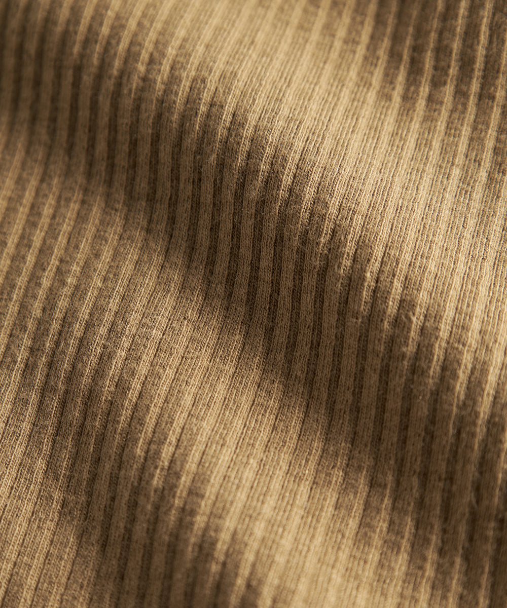 Detalje af ribstrikket brunt stof på børnehue