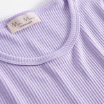 Detalje af ribstrikket stof ved halsudskæringen på lys lilla dame t-shirt