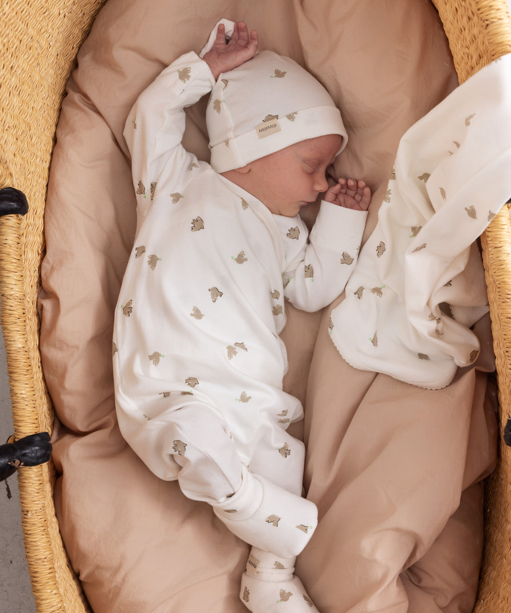 Baby ligger trygt i futter og babytøj