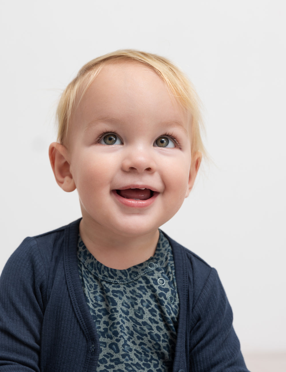 Baby in green leopard print long sleeve bodysuit