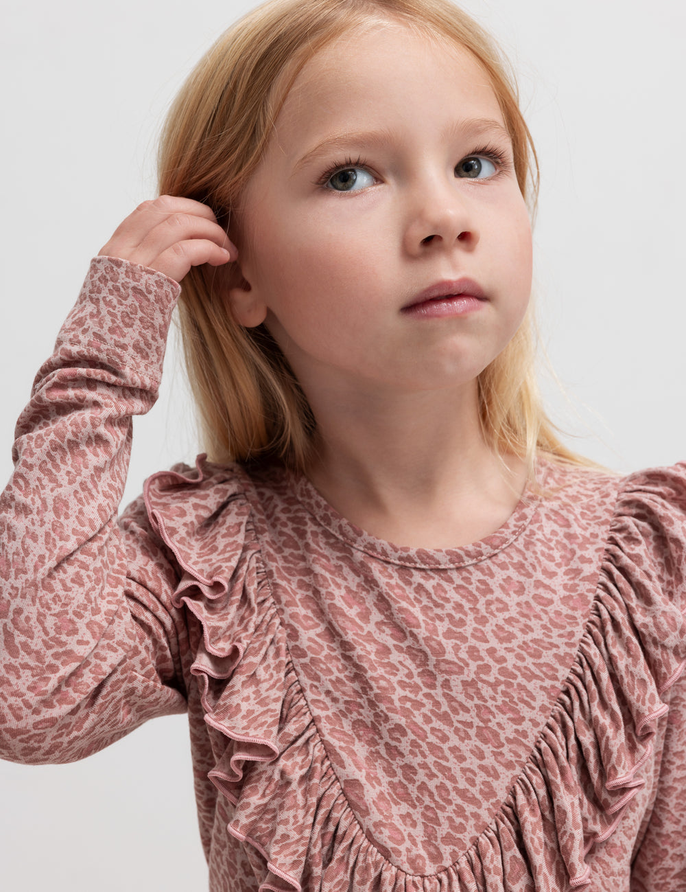 Pige iført lyserød leopardmønstret bluse med flæsedetalje