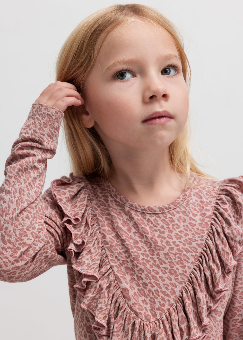 Pige iført lyserød leopardmønstret bluse med flæsedetalje