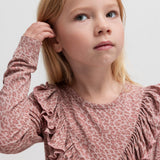 Pige iført lyserød leopardmønstret bluse med flæsedetalje