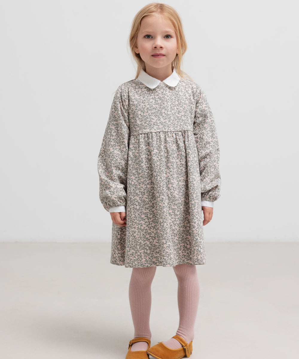 Børn iført lys kjole står mod en hvid baggrund