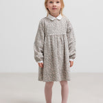 Børn iført lys kjole står mod en hvid baggrund