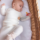 Baby iført hvide pointelle bukser og body liggende i en kurv