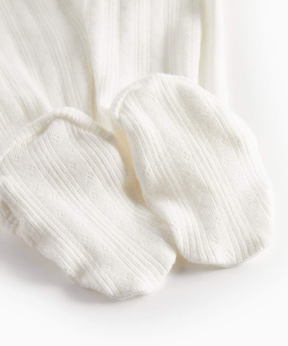 Hvid pointelle heldragt til baby med fødder og slå-om lukning