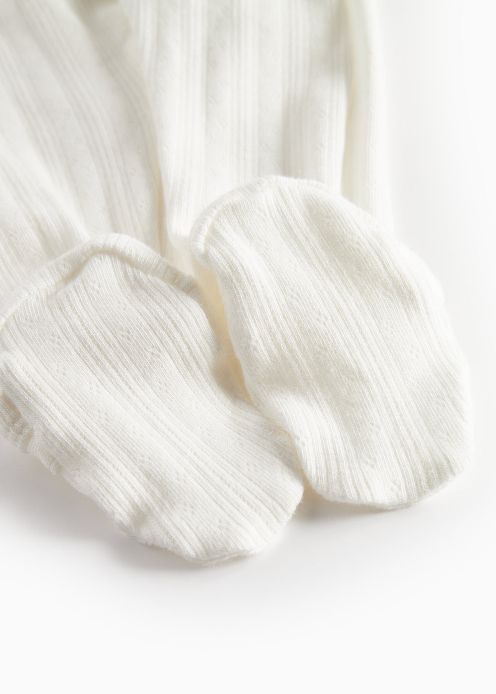 Hvid pointelle heldragt til baby med fødder og slå-om lukning