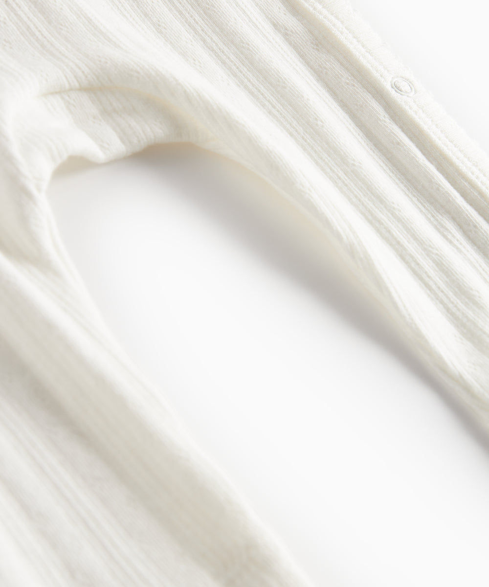 Hvid pointelle heldragt til baby med slå-om lukning og lange ærmer