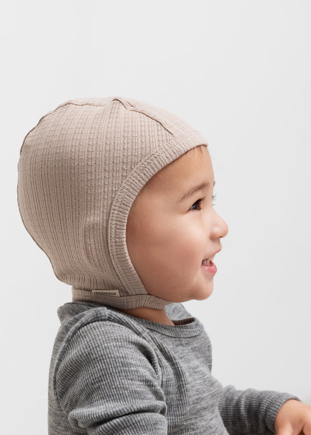 Børn iført beige ribstrikket elefanthue og grå bluse