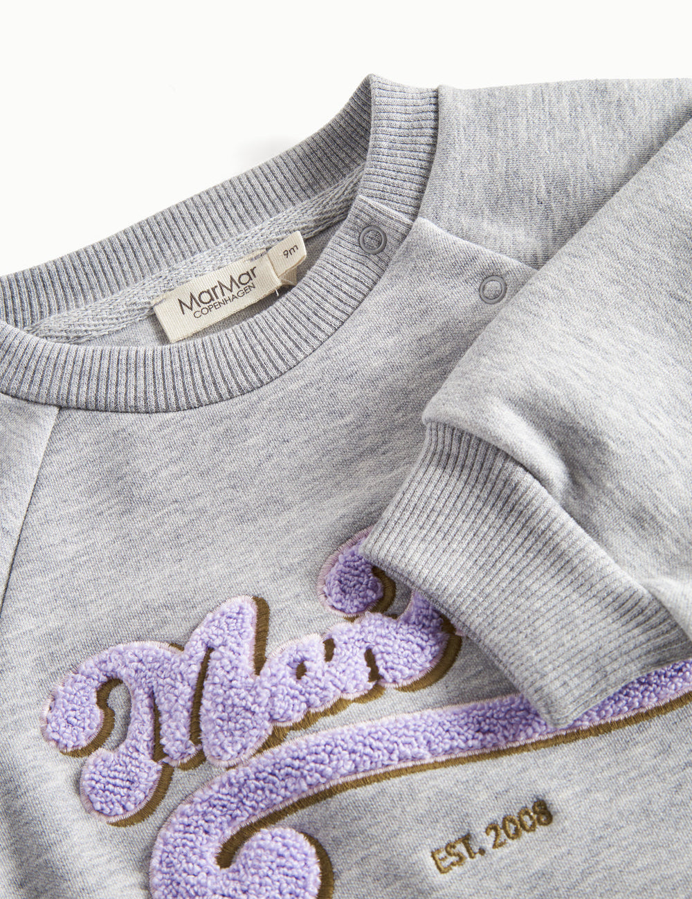 Close-up of embroidery and ribbed trim on gray sweatshirt for children