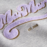 Detalje af lilla og guld broderi på grå sweatshirt til børn