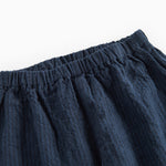 Detaljebillede af elastik i taljen på mørkeblå bukser